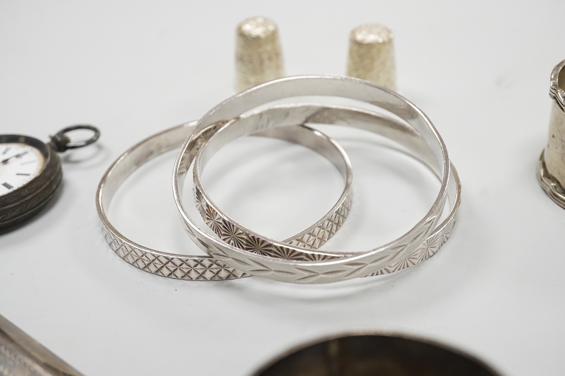 A collection of small silver to include a cigarette case, two napkin rings, three pairs of sugar tongs, a thimble, a lady's wrist watch and a mounted glass toilet jar. together with a 925 fob watch, a 935 mounted lighter